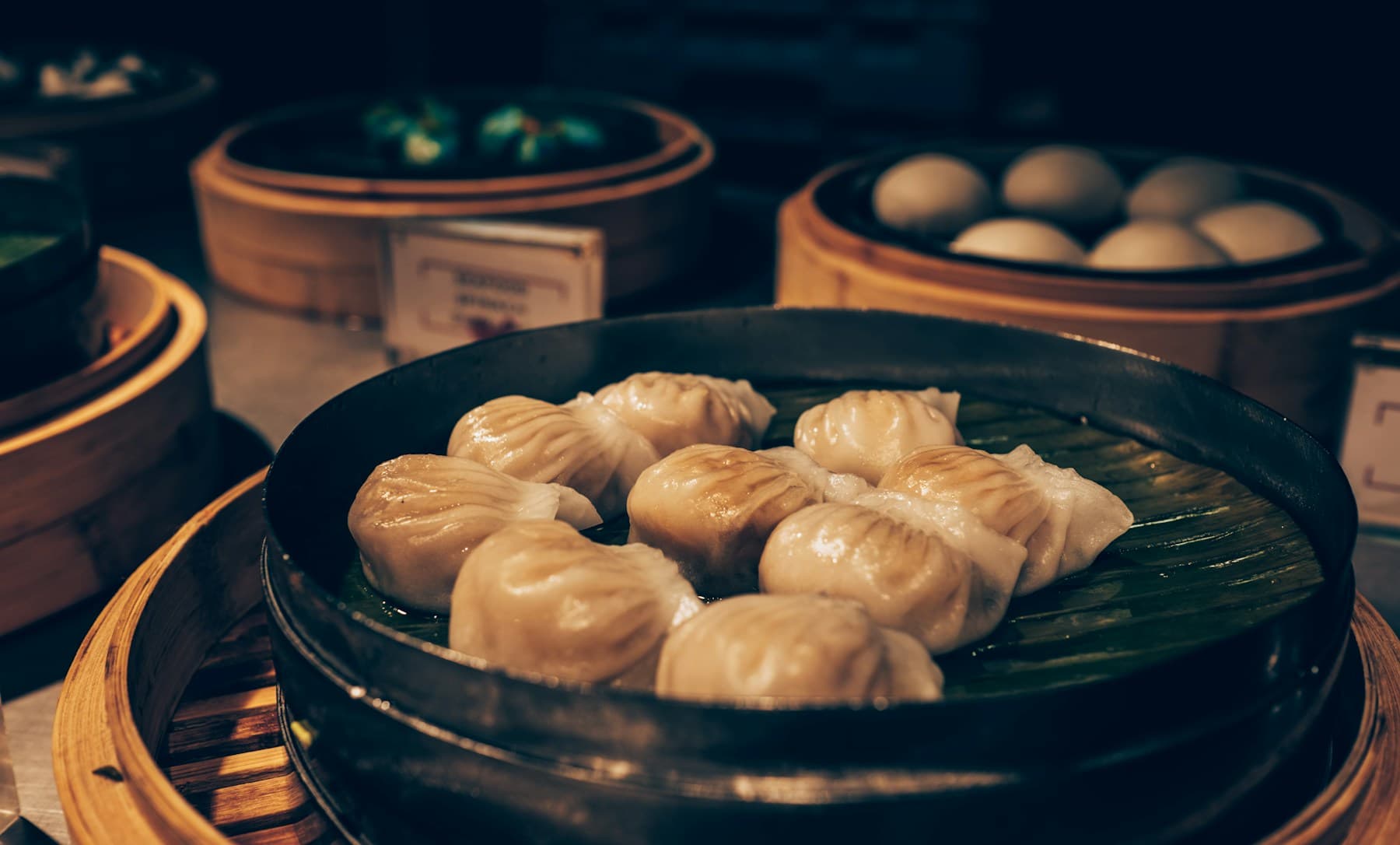 MO:MO dumplings served in a bamboo steamer lined with a leaf